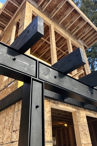 Dimensional lumber framing above black structural connections during construction